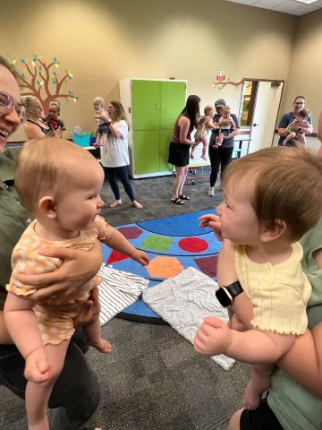 Image of two babies smiling at each other.