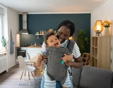 Image of parent with baby in a carrier.