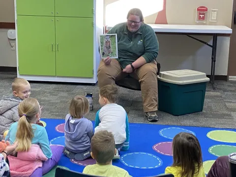 Image of Miss Erica reading a story to kids.