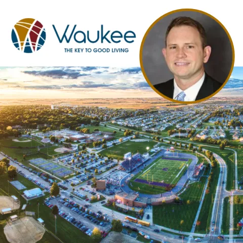 The city of Waukee logo and the headshot of a man in a suit hover over a sky view of part of the City of Waukee
