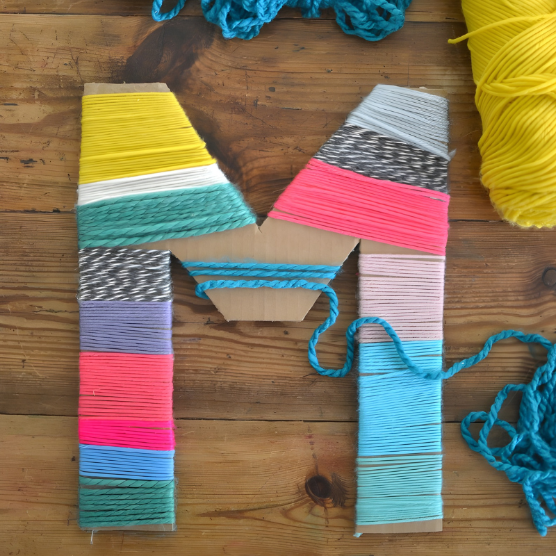 Image of a cardboard letter wrapped in yarn.